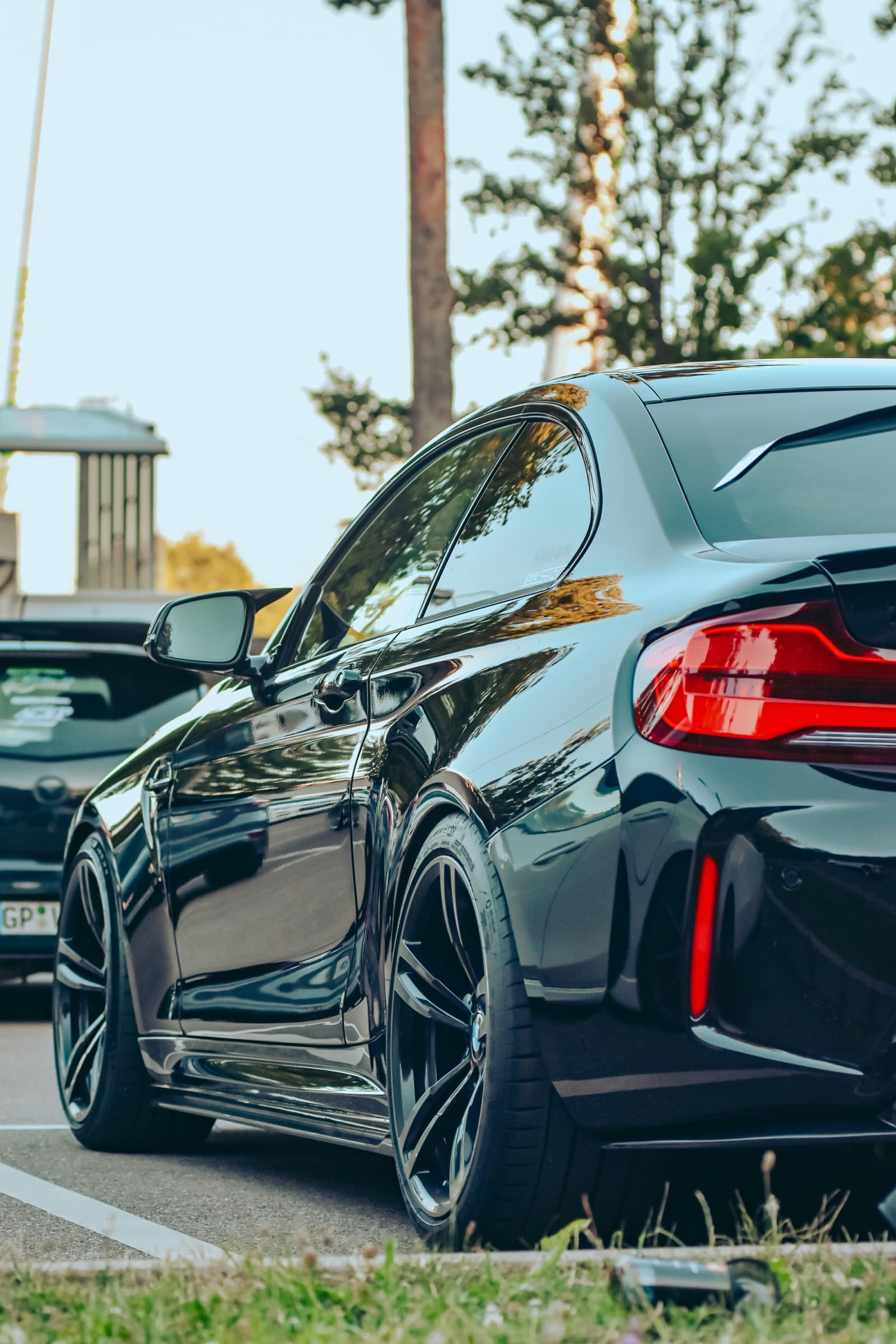 A glossy black car parked outdoors with clean reflective paintwork