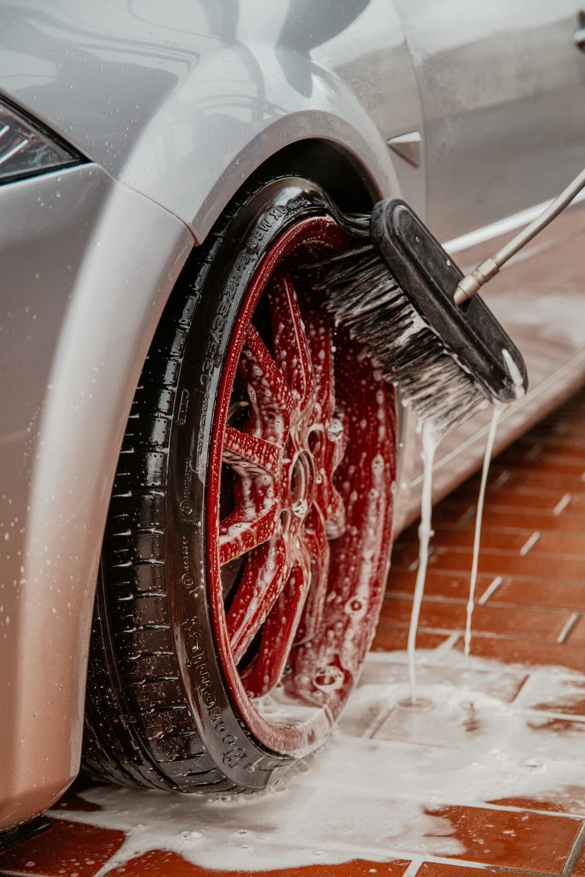 Wheel brush cleaning a foamy red wheel